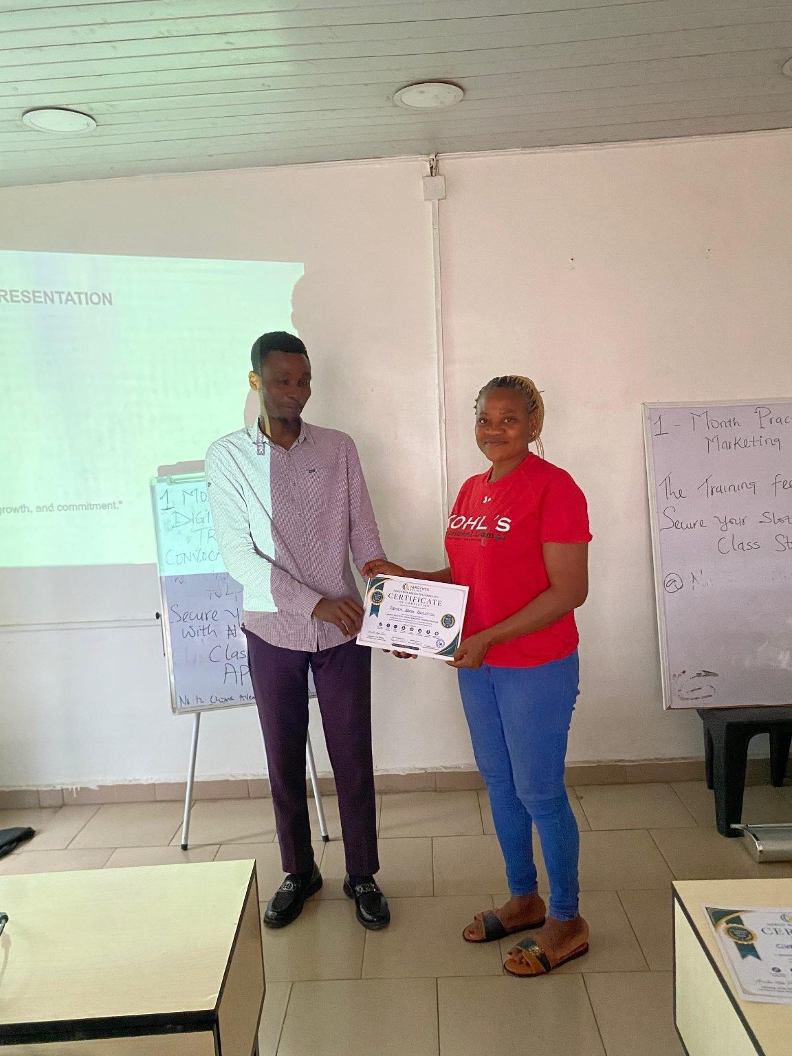 A Batch A student holding his practical training completion certificate